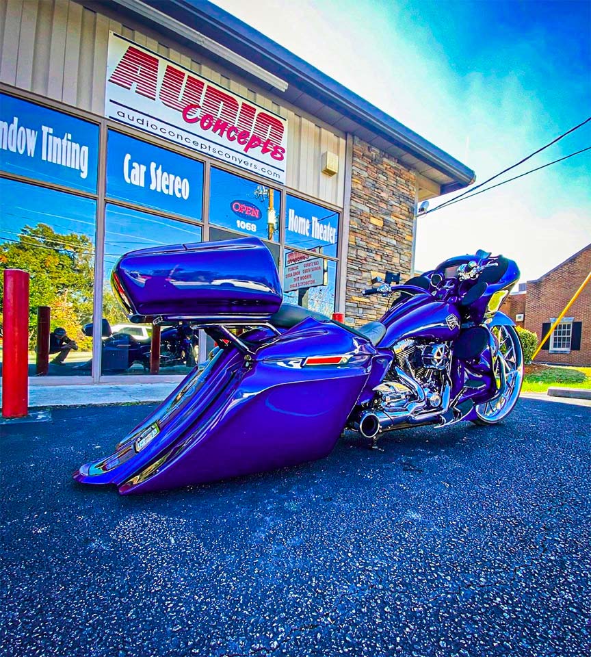 Photo of motorcycle in front of Audio Concepts storefront