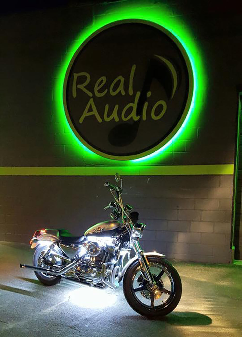Photo of Real Audio store front with motorcycle in shot